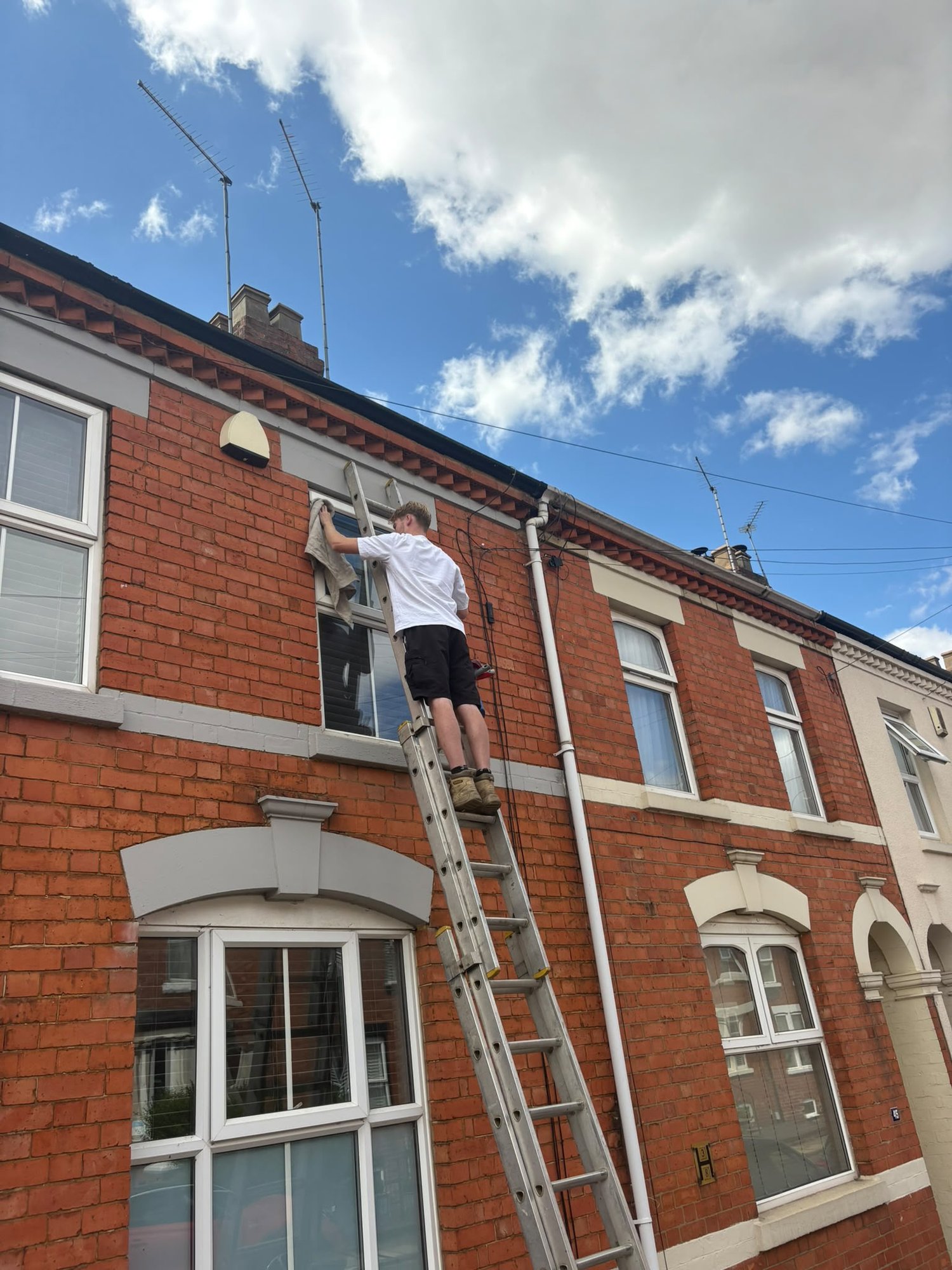 Ladder up to an upstairs window against blue sky