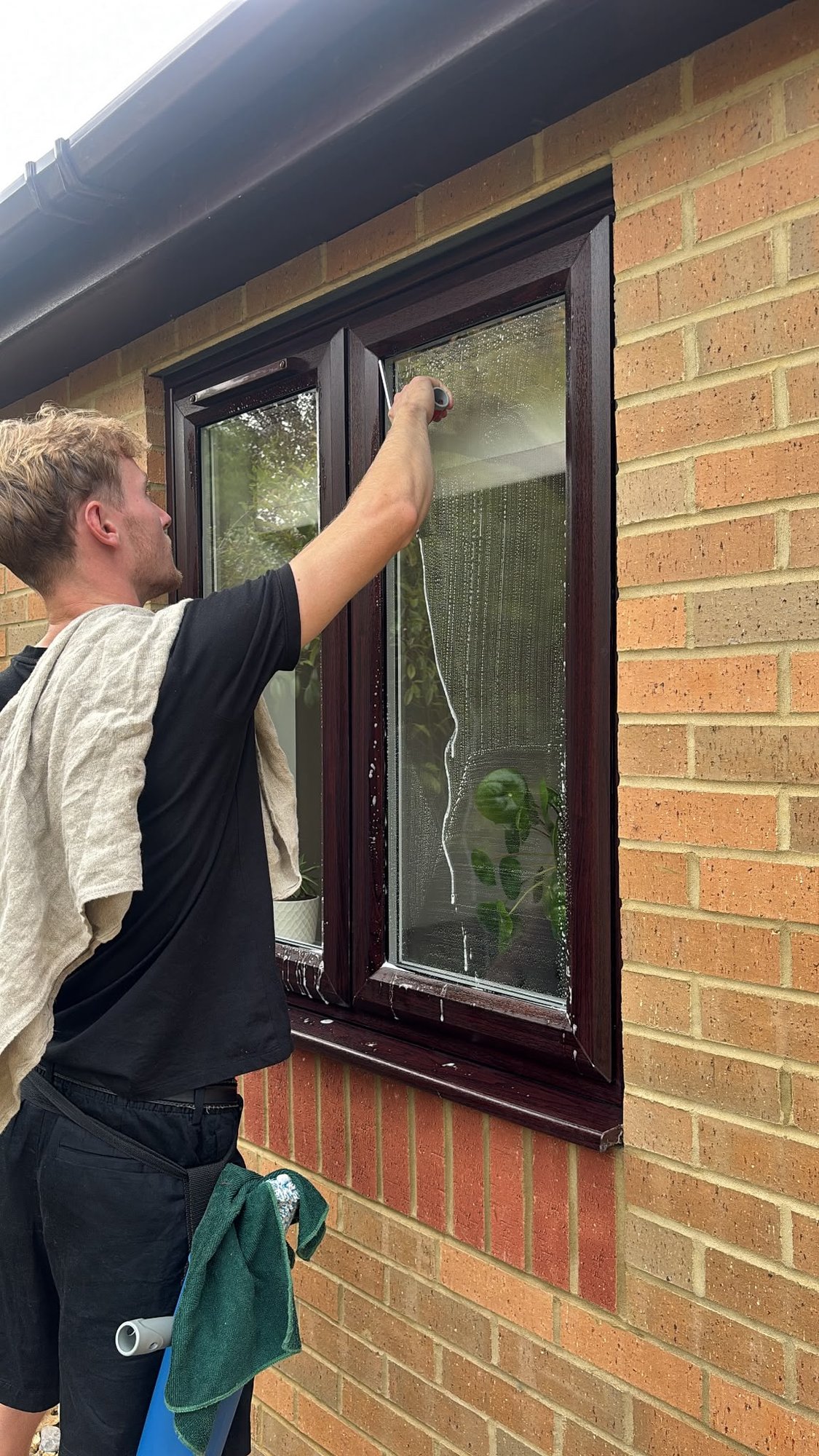 Applicator being worked across an upstairs window