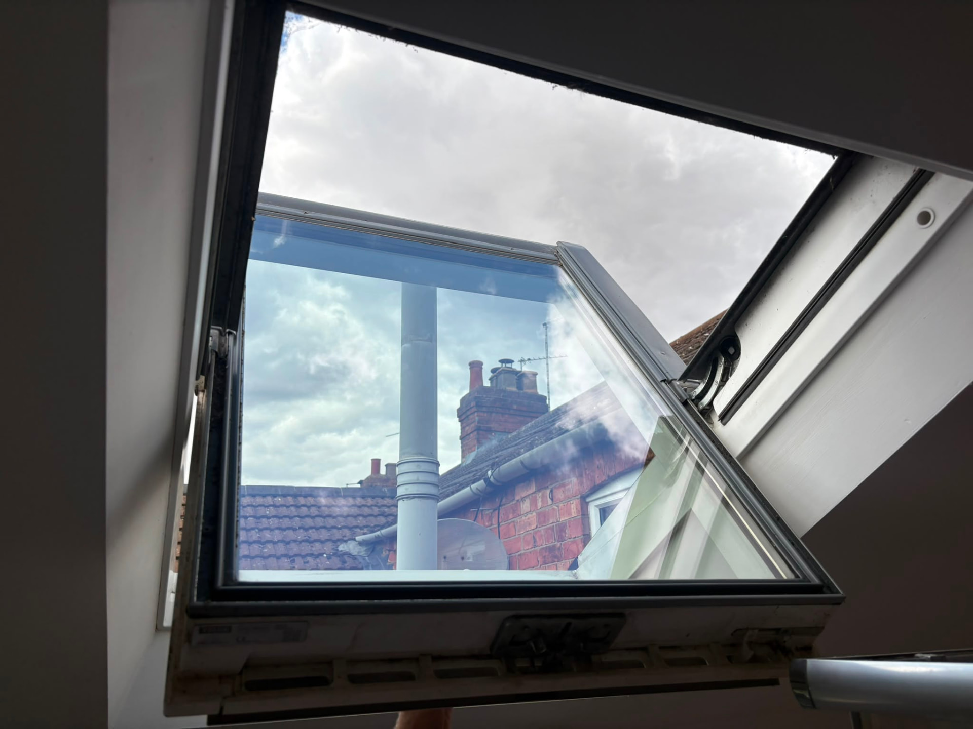 Cleaned Velux window opened out over the rooftops